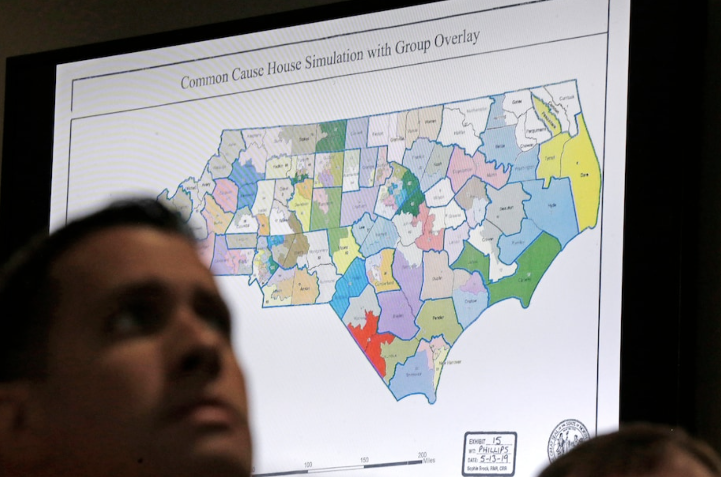 A districts map is shown as a three-judge panel of the Wake County Superior Court presides over the trial of Common Cause v. Lewis at the Campbell University School of Law in Raleigh, N.C., Monday, July 15, 2019. (Gerry Broome/AP)